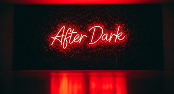 After Dark neon sign in red on grass wall