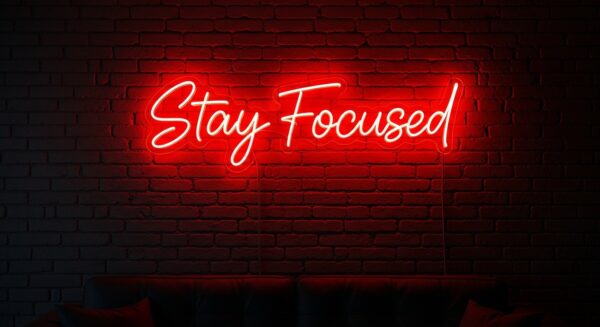 Stay Focused neon sign in red on brick wall