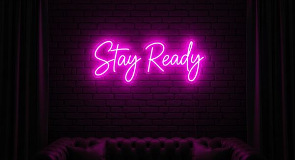 Stay Ready neon sign in pink on brick wall